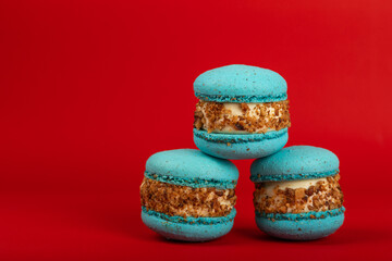 French pasta on a red background. Macarons with dor blue and pear. French dessert. Sweet table. Copy space. Place for text.