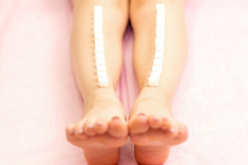 The concept of epilation, waxing. Sugar cubes lie down in a row on the naked white female leg