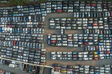 Aerial view of big parking lot of junkyard with rows of discarded broken cars. Recycling of old vehicles