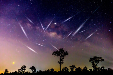 meteorites fly in the night sky. Silhouette Couple cycling on Panorama blue night sky milky way and...