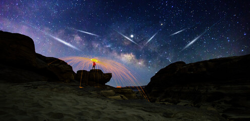 meteorites fly in the night sky. Silhouette Couple cycling on Panorama blue night sky milky way and...