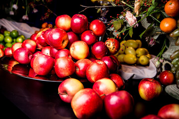 Lots of red apples on a black table.