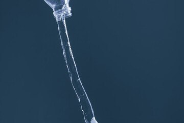 Splash of water from a bottle on a blue background. Reflection on the surface of the water.