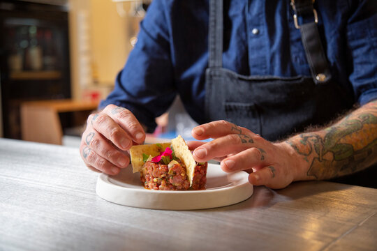 Unrecognizable chef putting crackers in tartare