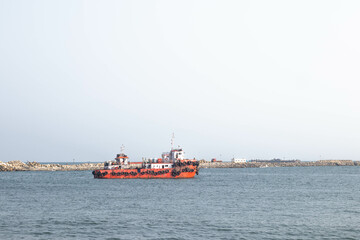 Small red fishing boat in blue sea