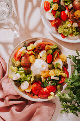 Fresh mediterranean salad with tomatoes and burrata cheese, top view