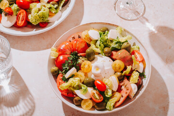 Fresh mediterranean salad with tomatoes and burrata cheese, top view