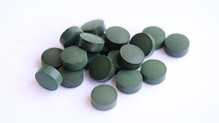 Obraz na płótnie Canvas Spirulina pills isolated on white background, close up.