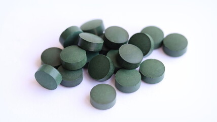 Spirulina pills isolated on white background, close up.