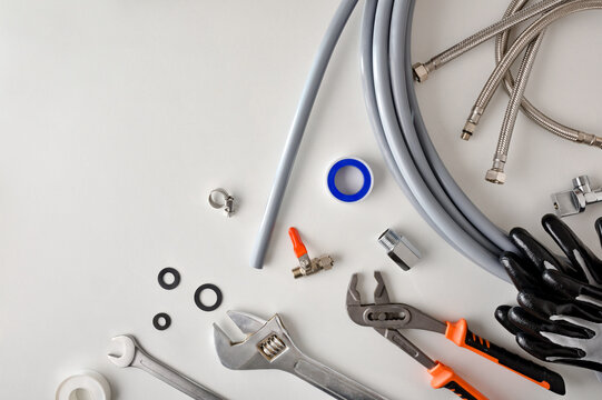 Group Of Plumbing Materials And Tools On White Workbench Top