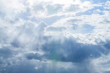 Beautiful cloudscape. Sunlight shines through the clouds in the evening sky. Nature background