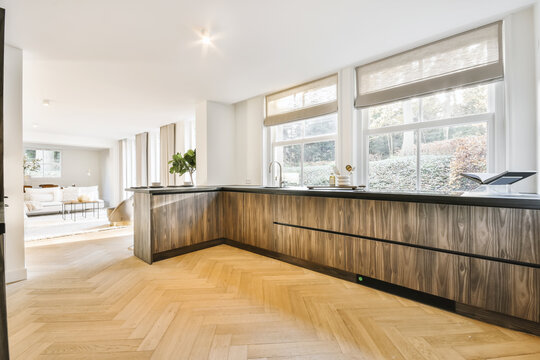 Contemporary kitchen with wooden furniture separated from living room with counter