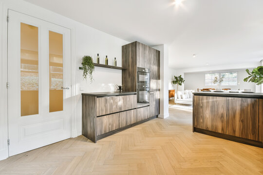 Contemporary kitchen with wooden furniture separated from living room with counter