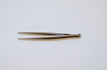 Tweezers and screwdriver for repairing electronic gadgets on a white background. The desktop of a mechanical engineer