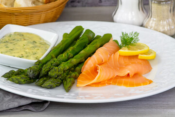 delicious salmon with asparagus and sauce on white plate