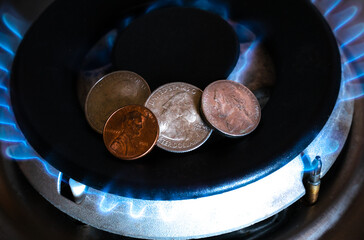 American cent coins on the gas stove. Increase in the cost of the gas bill. Expensive natural gas....