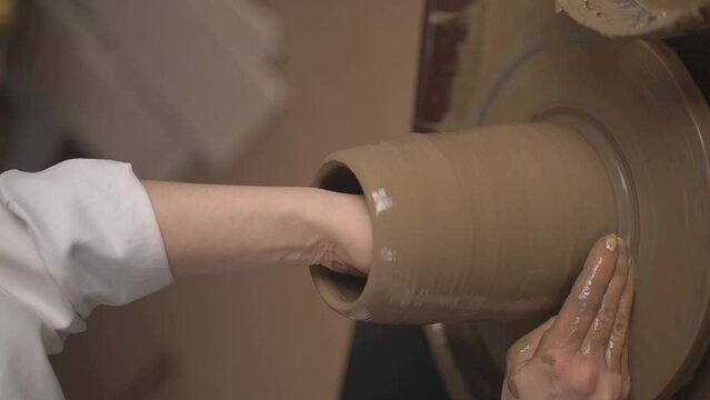 the girl works glina on a potter's wheel.vertical video.