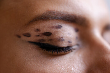 Close-up of eye makeup. Animal modern print on eyelids is a creative trend. Leopard coloring in...