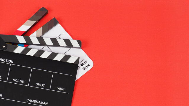 Two Black and white clapper board or movie slate on red background. crop shot
