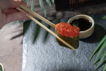 Gunkans with red caviar on a dark background