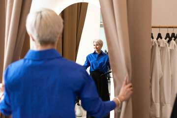 Obraz premium shopping concept - woman stylist or buyer posing at the shop at fitting room