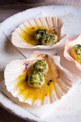 Baked scallops with herbs in a shell. Dish in a restaurant close-up.