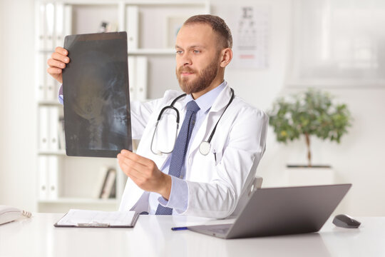 Young male doctor examining x ray image in the office