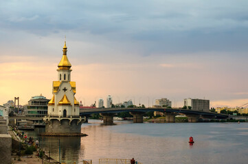 Kyiv, Ukraine. July 19. 2014. View of the Dnieper with an Orthodox church in the water, a bridge...