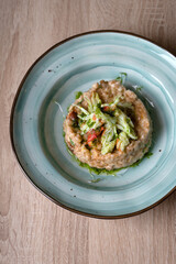 Meat pate with vegetables on a gray plate.