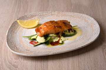 Salmon steak with sauce. Vegetable garnish.