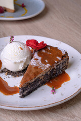 Piece of poppy seed cake with a scoop of vanilla ice cream