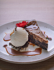 Piece of poppy seed cake with a scoop of vanilla ice cream