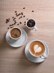 Americano and cappuccino in white cups with saucers on a beige table