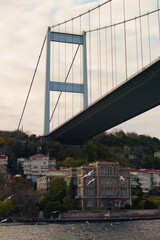 Scenic landscape view of pylon of The Fatih Sultan Mehmet Bridge ("Sultan Mehmed the Conqueror Bridge"), also known as the Second Bosphorus Bridge. Buildings under the bridge. Istanbul, Turkey