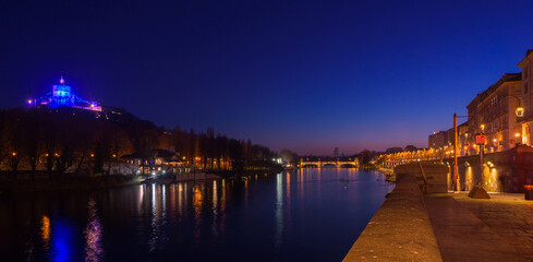 Fototapeta premium Turin, Italy. February 15, 2022. View of the Po river at night with the Church of Santa Maria del Monte dei Cappuccini on the left and Umberto I Bridge at the center.