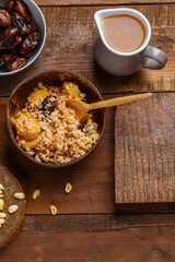 A plate of couscous with saffron and nuts on a wooden table nearby and a jug of fruit broth.