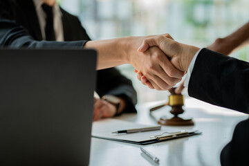 business people shake hands to make an agreement male lawyers judge legal advisors Various contract consulting services to plan a court case with a hammer placed in the back of the office