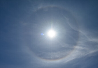 Optical phenomenon called 22 degree halo around the sun. Ice crystals in the atmosphere refract light and create the halo.