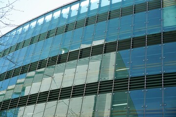 Fototapeta na wymiar Glasfassade mit Spiegelung von Parkhaus in Stadt 