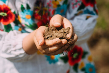 child is holding a handful of native land. Ukrainians lost homes and land. A piece of the homeland...
