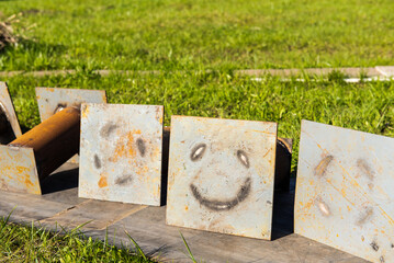 welded metal supports against the background of grass in the country. A smile made by welding. Cheerful background on the theme of summer and garden work
