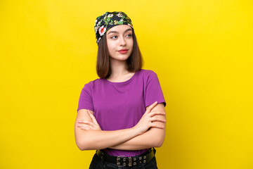 Young Ukrainian woman isolated on yellow background looking to the side