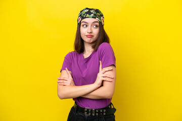 Young Ukrainian woman isolated on yellow background making doubts gesture while lifting the shoulders