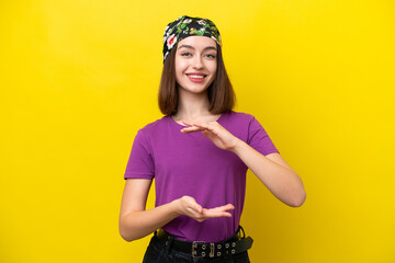 Young Ukrainian woman isolated on yellow background holding copyspace imaginary on the palm to insert an ad