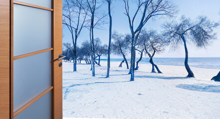 Open door in front of snow landscape in winter season. winter concept