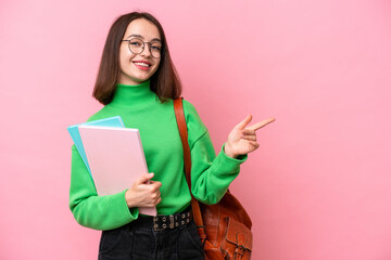 Young student Ukrainian woman isolated on pink background pointing finger to the side - obrazy, fototapety, plakaty