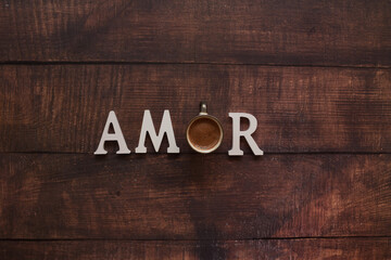 Palabra amor con la o de taza de café en mesa de madera