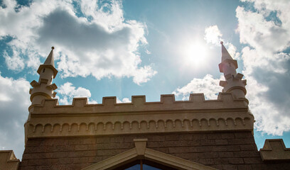 View of the ancient fortress wall with turrets in the sunlight on a clear day against the blue sky. Medieval architecture, world tourism. © Victor1153