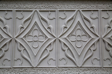 A kind of white stucco in the form of squares and rhombuses with flowers inside. Medieval architecture, world tourism.