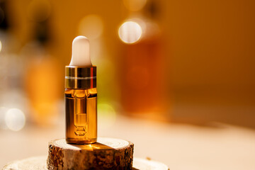 Cosmetic glass dropper bottle on wooden podium with oil, serum or fruit peeling in the sunlight....